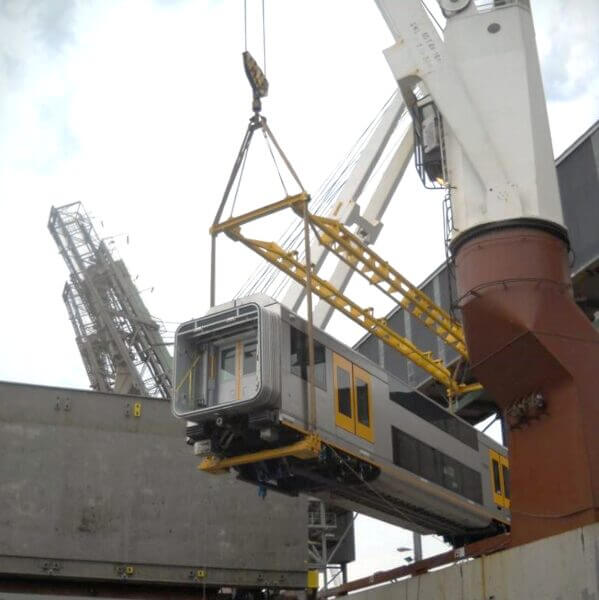 A ship's crane lifting a train carriage ready for shipping