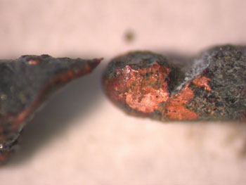 The image depicts high-magnification of two ends of copper wires after an arc strike between them, showing characteristic notch and melted droplet from a previous Hawkins case