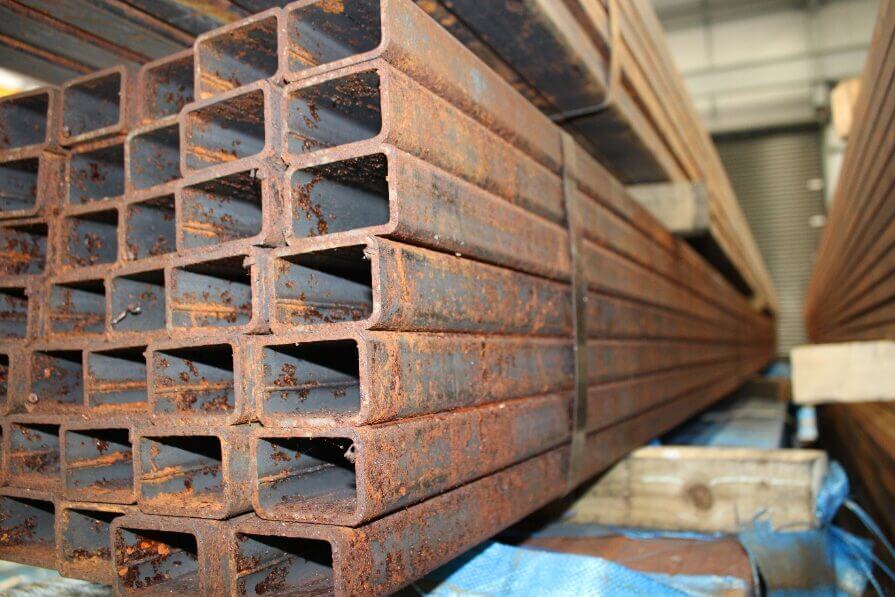 the Image shows a large number of metal steels stacked upon one another building rust