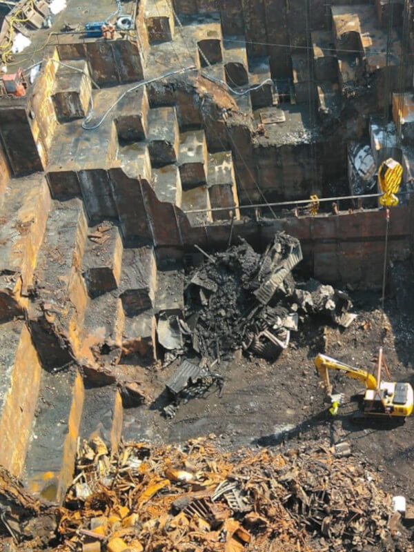 working to remove fire debris and damage from a cargo ship